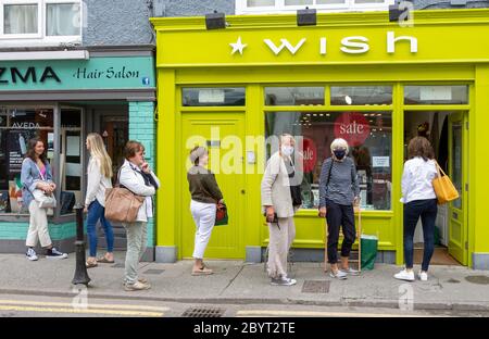 Les femmes qui font la queue avec des masques epi Skibbereen Ireland Banque D'Images