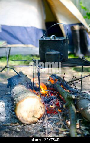 Tasse de chaudière touristique et chauffée sur un feu de bois Banque D'Images