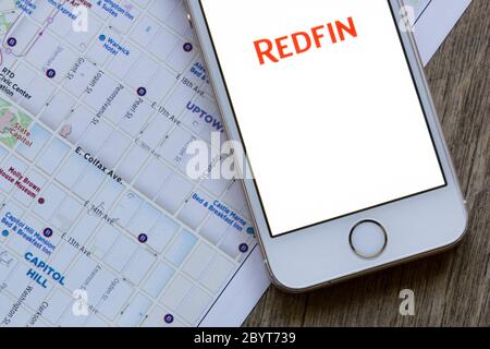 La page d'accueil de l'application mobile Redfin est affichée sur un smartphone, sur fond de plan de la ville. Redfin est une société de courtage immobilier basée à Seattle. Banque D'Images