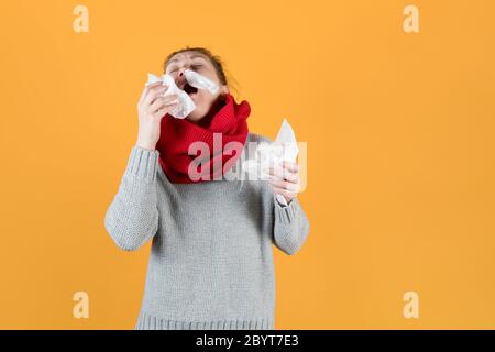 malade fille avec des serviettes dans ses mains éternue, jetant sa tête vers l'arrière Banque D'Images