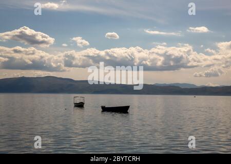 Un bateau de pêcheur vide sur le lac Ohrid par une journée d'été nuageux, ville d'Ohrid, République de Macédoine du Nord (ARYM) Banque D'Images