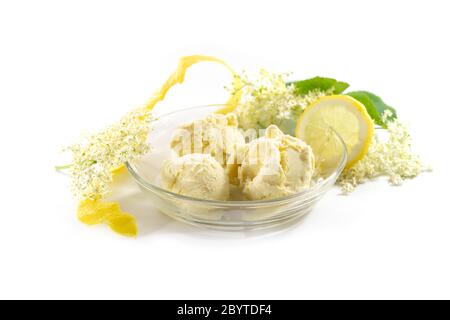 Glace de fleurs de sureau dans un bol en verre, zeste de citron et tranches et quelques fleurs fraîches isolées sur un fond blanc, espace de copie, sélectionné Banque D'Images