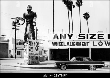 Auto tire shop avec figure publicitaire géant en face sur Lincoln Blvd. À Santa Monica, vers les années 1970 Banque D'Images