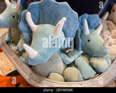 Un bac de jouets de dinosaure triceratops bleus farcis dans un magasin de détail. Banque D'Images