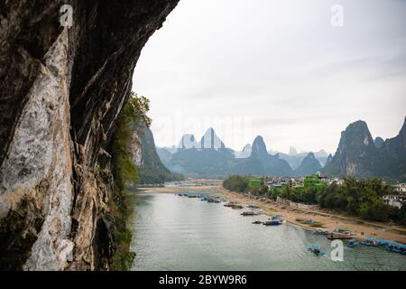 La vue sur le fleuve Li et les montagnes karstiques / collines et bateaux de croisière à Yangshuo, Guangxi, Chine, l'une des destinations touristiques les plus populaires de Chine. Banque D'Images