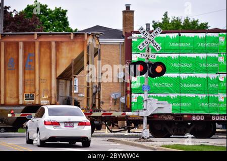 Franklin Park, Illinois, États-Unis. La voiture attend à un passage à niveau protégé par des feux clignotants et une rambarde descendue. Banque D'Images