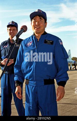 Comme le commandant de STS-87 Kevin Kregel le regarde, le spécialiste de mission Takao Doi, Ph.D., de l'Agence nationale de développement spatial du Japon s'adresse aux membres de la presse et des médias au centre de navette de Kennedy Space Center après leur arrivée pour les dernières activités de prélancement qui ont précédé le décollage prévu du 19 novembre. Les autres membres de l'équipage du STS-87 qui ne sont pas représentés sont le pilote Steven Lindsey; les spécialistes de mission Kalpana Chawla, Ph.D., et Winston Scott; et le spécialiste de la charge utile Leonid Kadenyuk, de l'Agence spatiale nationale d'Ukraine. STS-87 sera le quatrième vol de la charge utile de microgravité a des États-Unis Banque D'Images