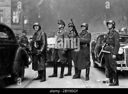 Blösche à droite, à côté de lui est Heinrich Klaustermeyer, à gauche est Karl Kaleske ou Erich Steidtmann avec Jürgen Stroop à gauche regardant des blocs de logements brûler pendant le soulèvement du ghetto de Varsovie. Photo prise à la rue Nowolipie en direction de l'est, près de l'intersection avec la rue Smocza. Sur le balcon à gauche de la maison Nowolipie 66. Banque D'Images