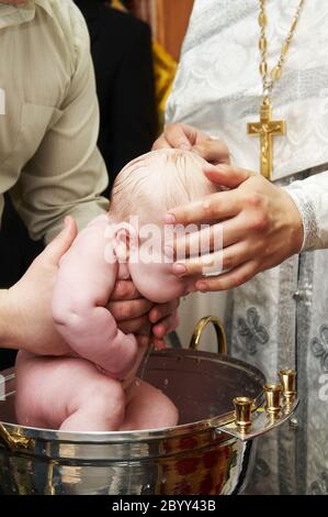 Baptême de bébé avec de l'eau en font Banque D'Images