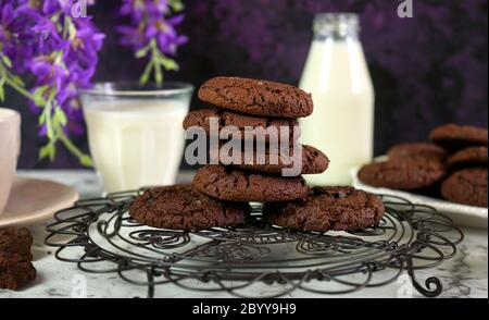 Pile de biscuits faits maison à double puce au chocolat dans un cadre vintage créatif sur fond de marbre violet et blanc. Banque D'Images