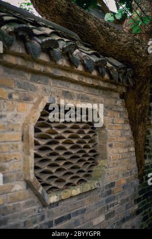 Fenêtres carrelées sur le mur extérieur des anciens bâtiments dans Villages chinois traditionnels Banque D'Images