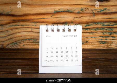 2020 AOÛT. Calendrier en papier blanc sur une table en bois. Planification du temps, comptage des jours et jours fériés Banque D'Images