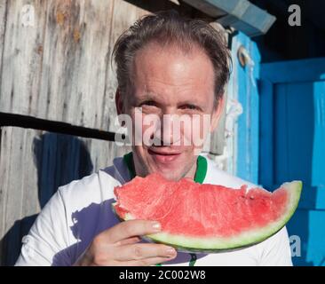 homme heureux avec un morceau de melon d'eau Banque D'Images