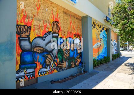 Peintures murales protestant contre le meurtre de George Floyd sur des panneaux de contreplaqué couvrant les fenêtres de la façade, Broadway, Santa Monica, Los Angeles, Californie Banque D'Images