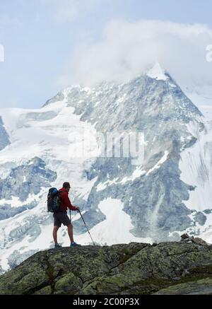 Photo verticale de la marche de routards avec des bâtons de randonnée. Incroyable, rocailleux Mont Ober Gabelhorn dans la neige dans les Alpes de Pennine en Suisse, situé entre Zermatt et Zinal. Concept de tourisme Banque D'Images