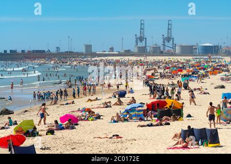 Porto, Portugal - juin 2019 : les gens se baignent au soleil sur la plage de Matosinhos, au bord de l'océan Atlantique. Familles appréciant l'été sur la rive de sable de po Banque D'Images