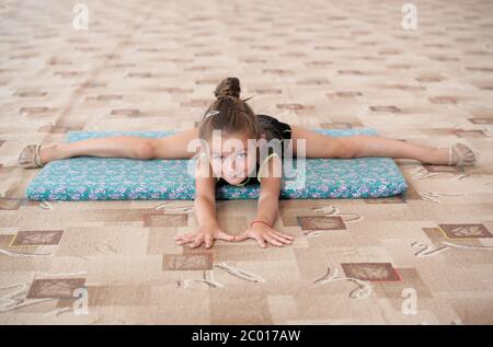 Little girl doing leg-split sur le plancher Banque D'Images