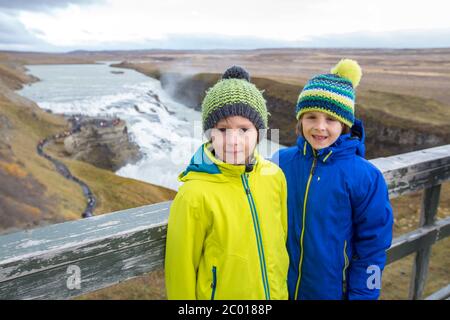 Enfants, appréciant la grande cascade majestueuse de Gullfoss dans les montagnes en Islande, Autumntime Banque D'Images