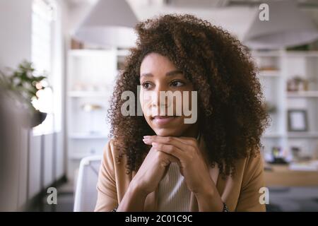 Portrait d'une femme d'affaires de race mixte pensant et souriant Banque D'Images