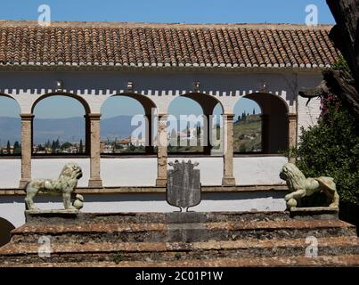 Deux lions de porcelaine verte de chaque côté d'un manteau de bras de métal sur une entrée fermée avec un passage couvert derrière l'Alhambra, par une chaude journée ensoleillée Banque D'Images