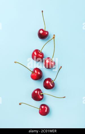 Composition de cerises mûres sur fond bleu. Banque D'Images