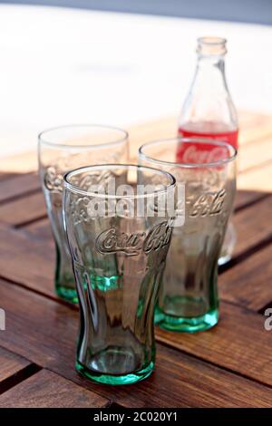 Vider les verres et la bouteille de Coca Cola sur une table en bois Banque D'Images