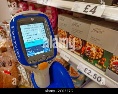 Lecteur de codes-barres dans un support sur un chariot de supermarché dans un magasin Tesco au Royaume-Uni - utilisé par les clients pour lire eux-mêmes les codes-barres sur les marchandises qu'ils souhaitent acheter. Banque D'Images