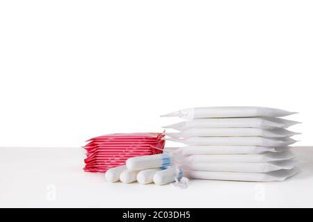 de nombreux tampons hygiéniques menstruels et tampons de coton sur fond blanc. Produits d'hygiène féminine Banque D'Images