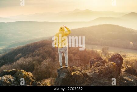 Homme au sommet d'une montagne en pleine ascension. Silhouette d'un homme sur la montagne au coucher du soleil Banque D'Images