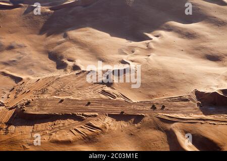 La construction d'une nouvelle piste d'atterrissage pour aider à la mise en place d'une grande installation de pétrole et de gaz dans le désert du Sahara. Banque D'Images