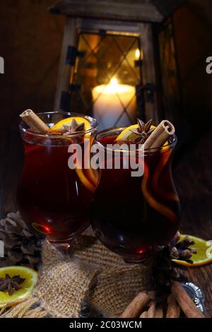 Vin chaud avec une orange, du miel, de la cannelle, une carnation et une anis, deux verres reliés par un foulard Banque D'Images