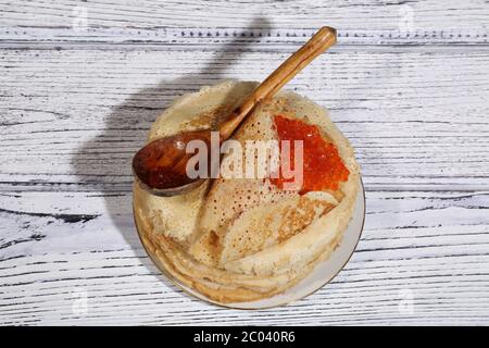 Caviar rouge enveloppé dans une mince fritter et une cuillère en bois Banque D'Images