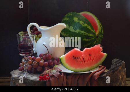 Encore-vie avec du vin, un melon d'eau, des raisins, une rose guelder et une carafe blanche Banque D'Images