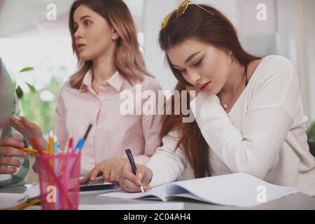 Cropped shot d'une belle jeune femme faire son affectation au collège, l'écriture d'un manuel, l'espace de copie. Belle female college student la préparation de f Banque D'Images