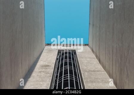 Vue à angle bas d'un escalier d'évacuation de feu externe en spirale d'un bâtiment avec ciel bleu. Banque D'Images