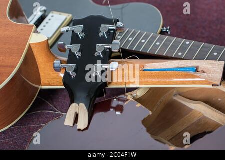 Guitares écrasées. Pile de morceaux de guitare électrique et acoustique cassés. Gros plan des instruments de musique endommagés, notamment la tête de lit, le cou et le corps du vario Banque D'Images