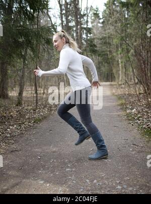 femme court sur la piste dans le bois de printemps Banque D'Images