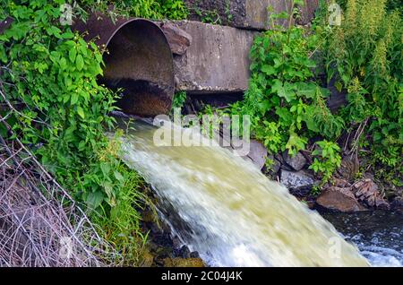 Décharge d'eau de la conduite dans la rivière Banque D'Images