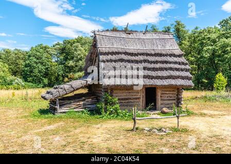 Petite cabane de berger avec toit de paille le jour ensoleillé. Banque D'Images