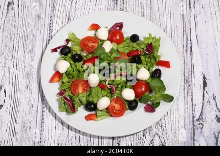 Salade avec tomates, mozzarella, olives, chou et roccola Banque D'Images