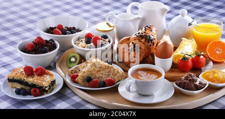 Le petit-déjeuner est composé de café, jus d'orange, croissants, crêpes, œufs, céréales et fruits. Banque D'Images