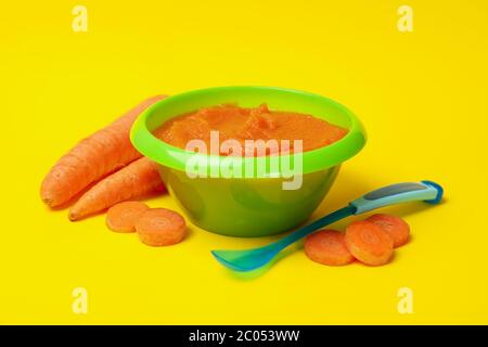 Bol avec purée de légumes sur fond jaune. Nourriture pour bébé Banque D'Images