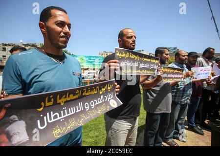 Les Palestiniens tiennent des pancartes pendant la manifestation. Les Palestiniens protestent contre les plans d'Israël d'annexer des parties de la Cisjordanie occupée, à Rafah, dans le sud de la bande de Gaza. Les plans ont l'intention d'annexer les colonies de Cisjordanie et la vallée du Jourdain, comme l'a proposé le Président des États-Unis. Banque D'Images