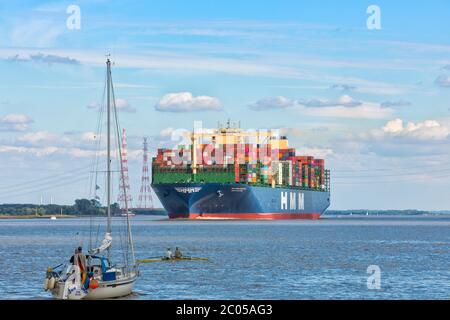 Stade, Allemagne - 10 juin 2020: Spectateurs sur des bateaux observant HMM ALGECIRAS, le plus grand navire à conteneurs au monde, exploité par Hyundai Merchant marin Banque D'Images