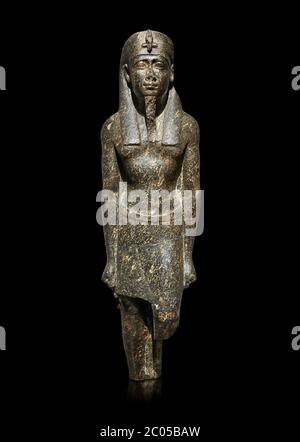 Ancienne statue égyptienne d'un roi ptoléméen dans la régalia pharaonique, granodiorire, période ptoléméenne (332-30BC). Musée égyptien, Turin. Fond noir Banque D'Images