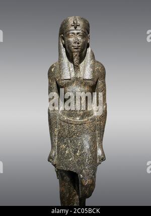 Ancienne statue égyptienne d'un roi ptoléméen dans la régalia pharaonique, granodiorire, période ptoléméenne (332-30BC). Musée égyptien, Turin. Fond gris Banque D'Images