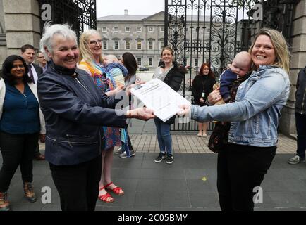 Tara MacDarby (à droite), avec son fils Calum (4mois), présente aux gens avant le profit Brid Smith une pétition pour Taoiseach Leo Varadkar demandant une prolongation de congé de maternité de 3 mois en raison de la crise Covid-19 à la Maison Leinster à Dublin. Banque D'Images