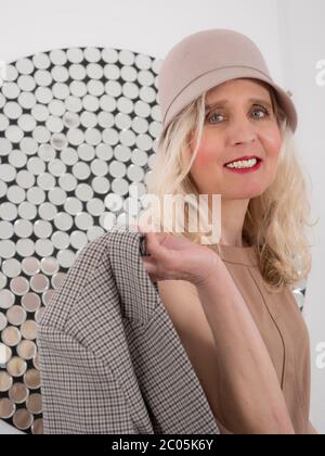 Portrait vertical d'une femme blonde sophistiquée tenant une veste Banque D'Images