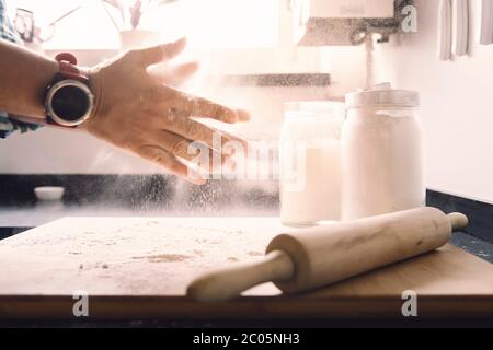 homme méconnu qui se claque avec de la farine sur la table de cuisine, concept de nourriture saine à la maison Banque D'Images