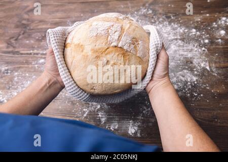 vue de dessus des mains d'une personne méconnaissable tenant un pain fraîchement cuit, concept de manger sain à la maison Banque D'Images